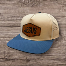 Load image into Gallery viewer, Beige and blue cap with 'JESUS' patch on a wooden surface
